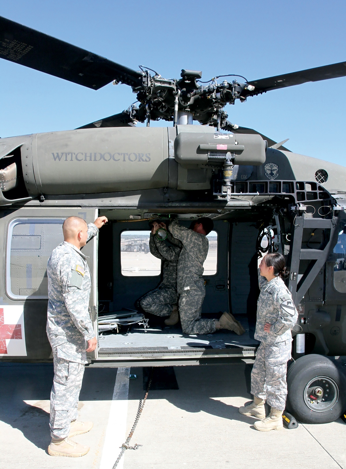 A photo of soldiers working on a helicopter