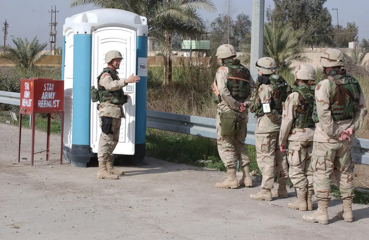 Soldiers stand in line at a “reenlistment office” in Baghdad on 25 February 2004.