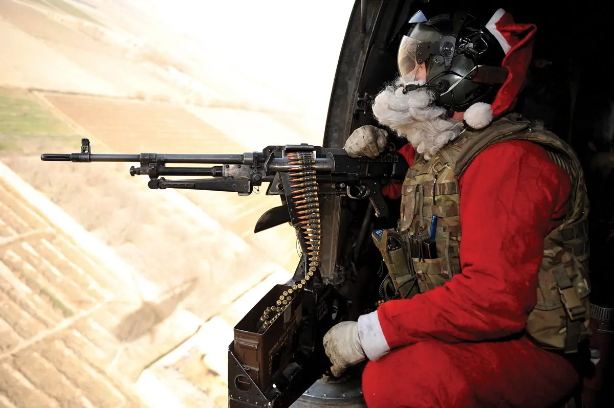 Door gunner Petty Officer Richard Symonds of the Royal Navy wears a Santa Claus outfit as he delivers mail and Christmas presents to troops around Helmand Province, Afghanistan, on 25 December 2010