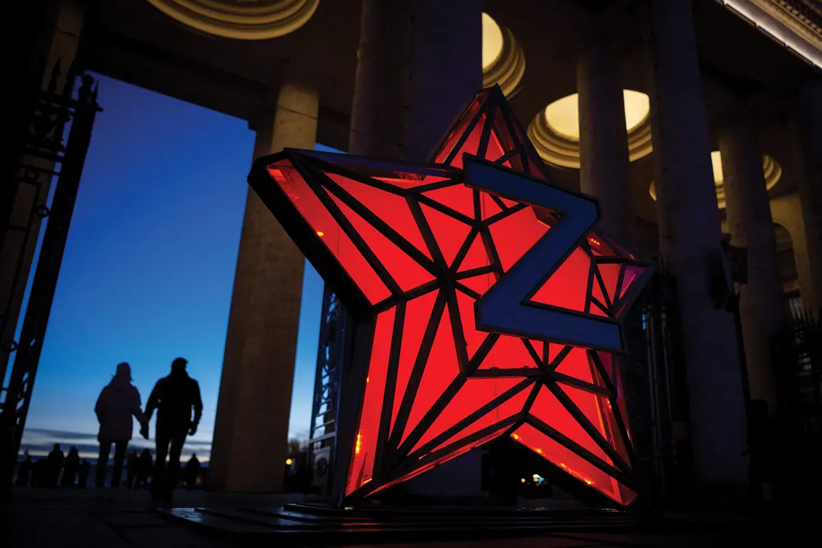 Pedestrians walk past a New Year decoration stylized as the “Kremlin Star” 2 January 2023 in Moscow