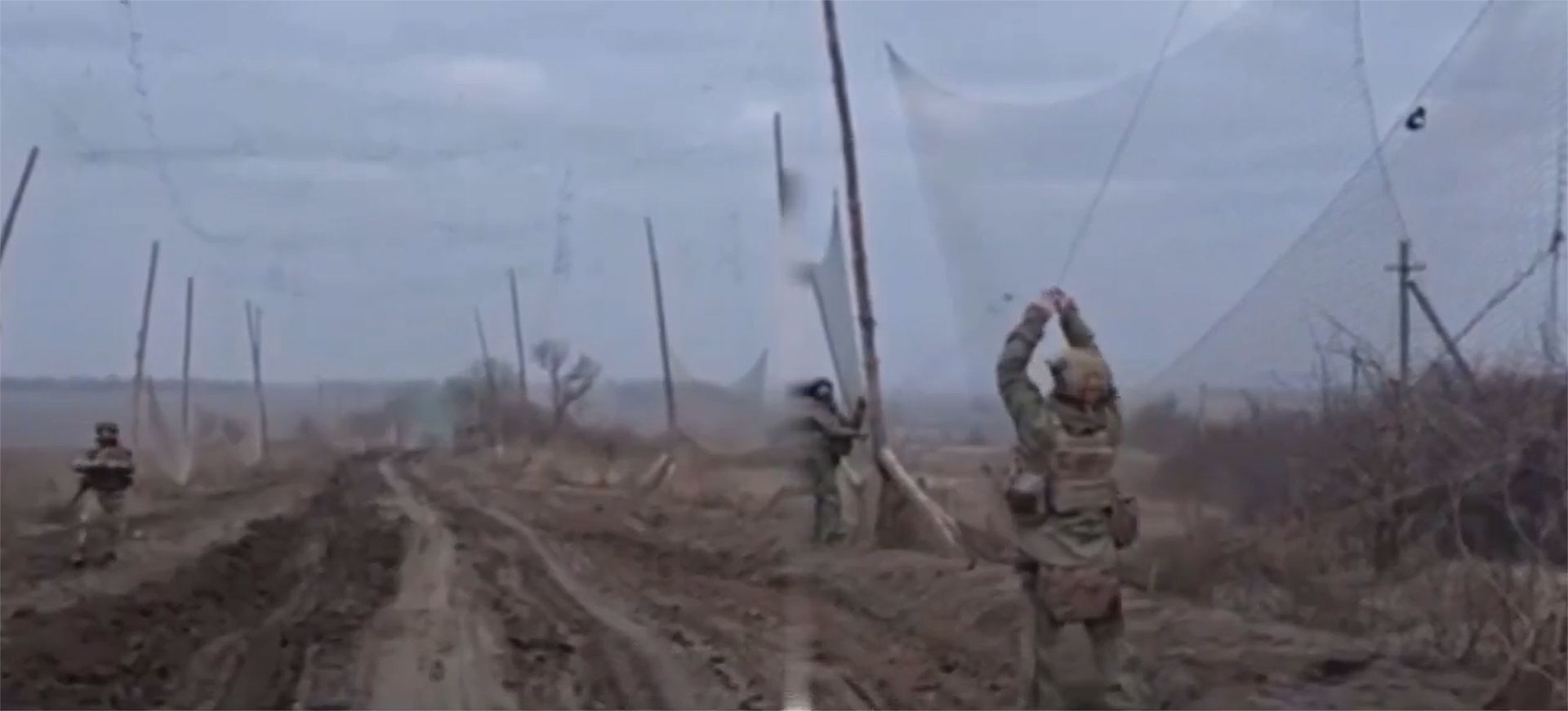 Russian troops build a two-kilometer mesh net “tunnel” in early 2025 to protect against Ukrainian FPV drones. In theory, FPV drones on their final attack trajectory will get entangled in the net or go off course. (Screenshot from X)