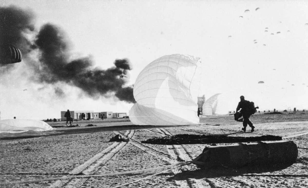 Paraquedistas britânicos deslocam-se para tomar as edificações do aeroporto cerca de cinco minutos após o primeiro lançamento no assalto aeroterrestre ao campo de pouso El Gamil, Porto Said, Egito, em 5 de novembro de 1956, durante a Crise de Suez