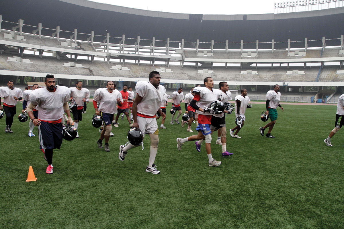 Jogadores indianos de futebol americano correm em campo, em 23 de março de 2012