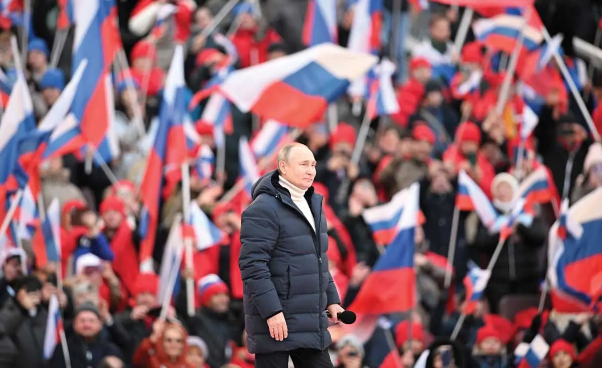Con un fondo de banderas ondeantes, el presidente ruso Vladimir Putin asiste a un concierto el 18 de marzo de 2022 en el estadio Luzhniki de Moscú para conmemorar el octavo aniversario de la anexión de Crimea a Ucrania por parte de Rusia