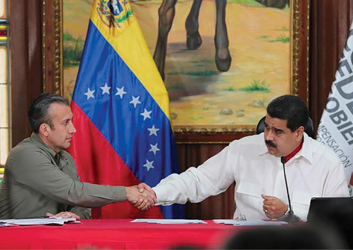 Venezuela’s President Nicolás Maduro (right) and Vice President Tareck El Aissami shake hands