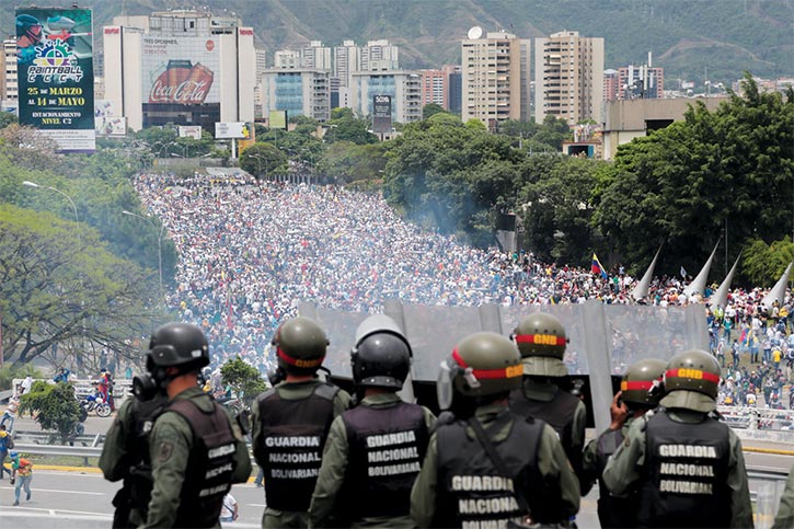 Venezuelan National Guard soldiers stand on a highway