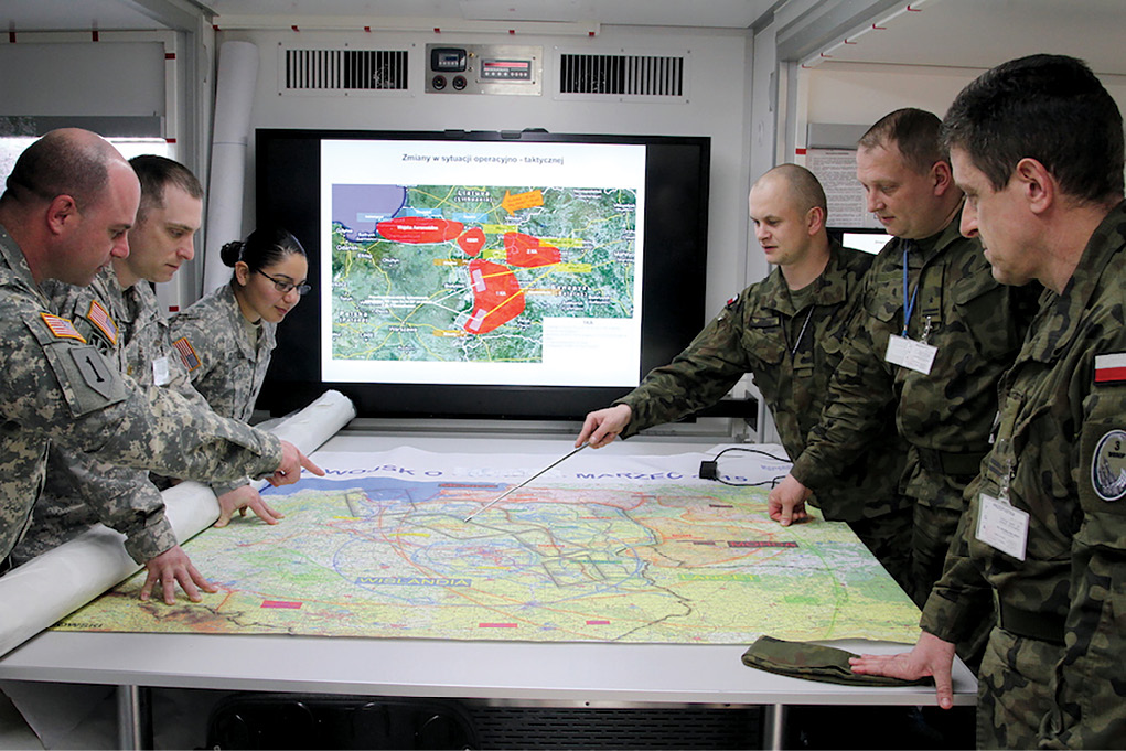 10th Army Air and Missile Defense Command operations officers work with Polish counterparts 24 March 2015 in the Surface Air Missile Operations Center at Sochachew Air Base, Poland. (Photo by Sgt. 1st Class Randall Jackson, U.S. Army)