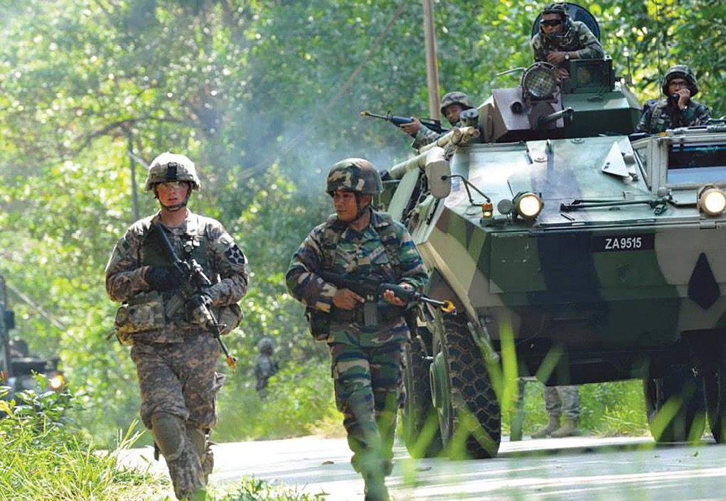 Pvt. 2nd Class Darrell Enger, 2nd Stryker Brigade Combat Team, 2nd Infantry Division (left), conducts a counter-improvised explosive device patrol with other U.S. and Malaysian Army soldiers 20 September 2014 during bilateral training exercise Keris Strike 14 in Kem Desa Pahlawan, Malaysia. Keris Strike is a U.S. Army Pacific-sponsored Theater Security Cooperation Program exercise conducted annually with Malaysian Army forces to enhance partner land-force capacity and capabilities. The exercises contribute to the regional peacekeeping capability in Asia. (Photo by Sgt. 1st Class Adora Gonzalez, U.S. Army)