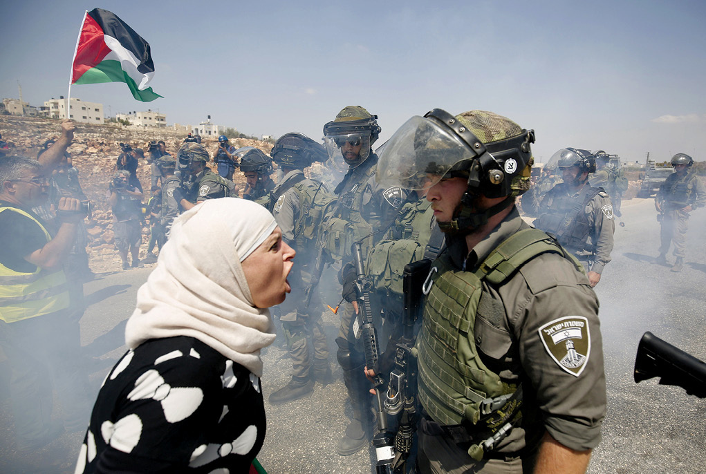 A Palestinian woman argues with an Israeli border policeman 4 September 2015 during a protest against Jewish settlements in the West Bank village of Nabi Saleh near the Palestinian city of Ramallah. (Photo by Mohamad Torokman, Reuters)