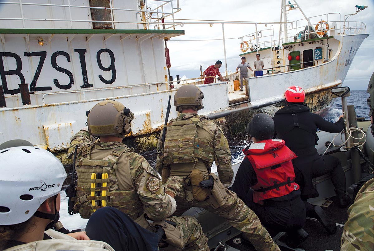 >U.S. Navy sailors and U.S. Coast Guard Pacific Law Enforcement Detachment Team personnel approach a Chinese fishing vessel on a rigid-hull inflatable boat 29 November 2016 during an Oceania Maritime Security Initiative mission with Arleigh Burke-class guided-missile destroyer USS <em>Sampson</em> (DDG 102) in the Pacific Ocean.