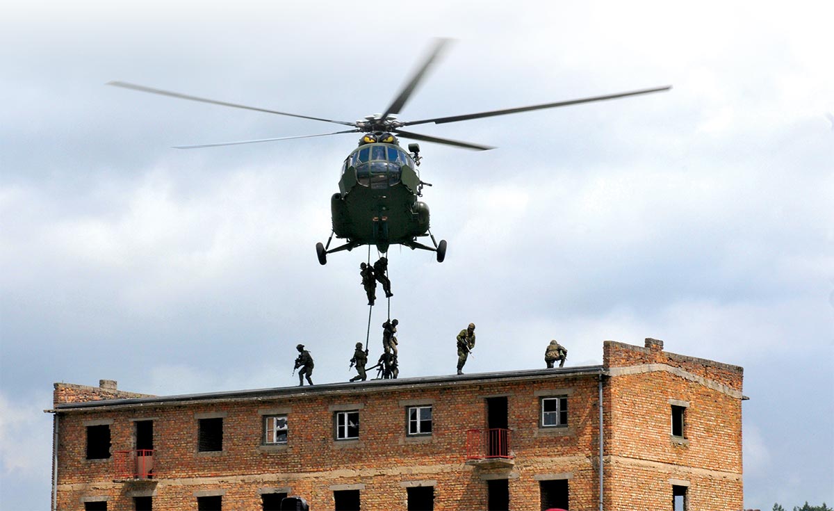 Soldiers conduct a fast-rope insertion onto a rooftop in urban terrain 14 June 2016 during Exercise Anakonda in Wedrzyn, Poland.