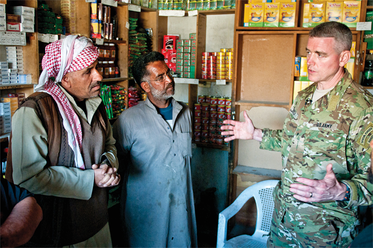 Brig. Gen. Jonathan P. Braga, director of operations for the Combined Joint Task Force–Operation Inherent Resolve, talks to shop owners