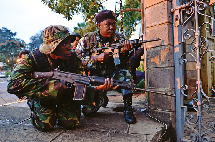 Kenyan soldiers take cover 23 September 2013 after heavy gunfire near Westgate Mall in Nairobi, Kenya.