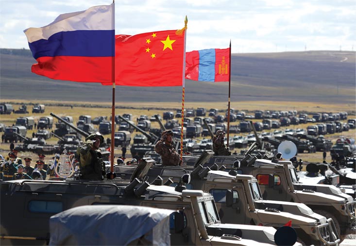 Russian, Chinese, and Mongolian national flags are displayed on armored vehicles 13 September 2018 during the Vostok 2018 military exercise on Tsugol training ground in Eastern Siberia, Russia.