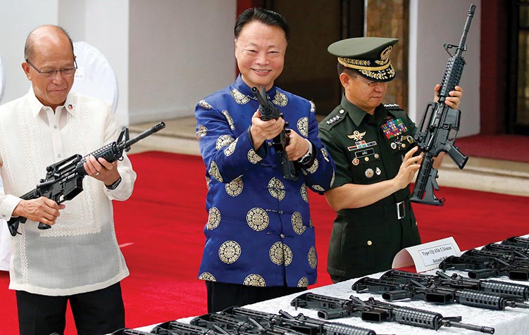 Philippine Defense Secretary Delfin Lorenzana (left), Chinese Ambassador to the Philippines Zhao Jianhua, and Philippine Armed Forces Chief Gen. Eduardo Ano (right) inspect Chinese-made CQ-A5b assault rifles 5 October 2017 during a turnover ceremony at Camp Aguinaldo in Quezon City, Philippines. The weapons and ammunition are part of China’s military donation to the Philippines’ fight against Muslim militants who laid siege to Marawi in southern Philippines. (Photo by Bullit Marquez, Associated Press)