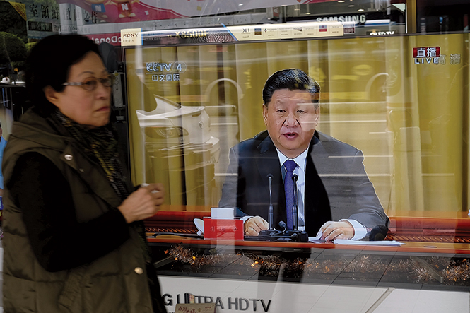A woman walks past a television in New Taipei City 2 January 2019 that shows China’s President Xi Jinping making a speech commemorating the fortieth anniversary of a message sent to Taiwan in 1979 that asserted Taiwan’s unification with the mainland is “inevitable.” Xi warned against any efforts to promote the island’s independence, saying China would not renounce the option of using military force to annex it. Xi continued, “After peaceful reunification, Taiwan will have lasting peace and the people will enjoy good and prosperous lives. With the great motherland’s support, Taiwan compatriots’ welfare will be even better, their development space will be even greater.” (Photo by Sam Yeh, Agence France-Presse))
