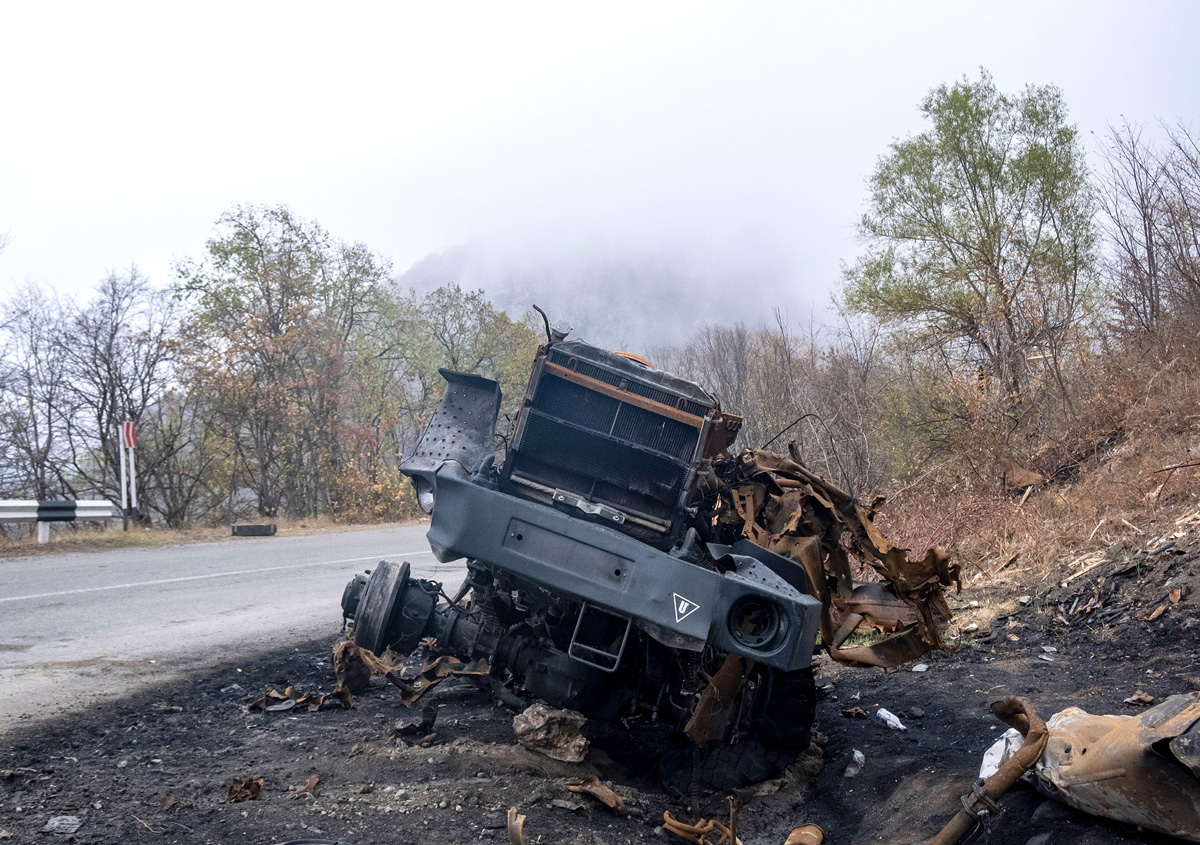 Photo of a destroyed military truck on the side of the road