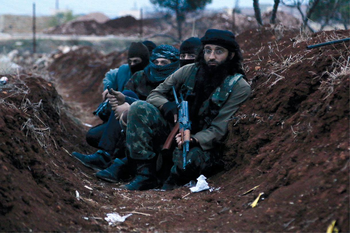 Integrantes da Frente al Nusra, da Al Qaeda, esperam em uma trincheira perto da aldeia de al-Zahra, ao norte de Aleppo, na Síria, 25 Nov 14. Integrantes da Frente al Nusra e outros insurgentes islamistas sunitas se chocaram com combatentes pró-governo ao tentarem se apossar da aldeia muçulmana xiita. (Foto de Hosam Katan, Reuters)