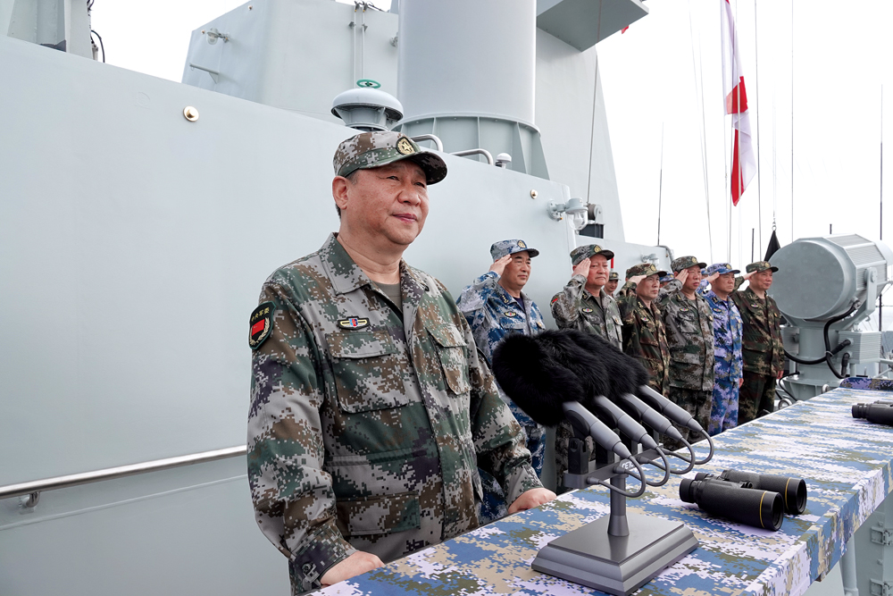 O Presidente chinês Xi Jinping (à esquerda), que também é o Secretário-Geral do Comitê Central do PCC e Presidente da Comissão Militar Central, passa em revista as forças navais, 12 Abr 2018, no Mar do Sul da China. (Foto de Li Gang, Xinhua via Agence France-Presse)