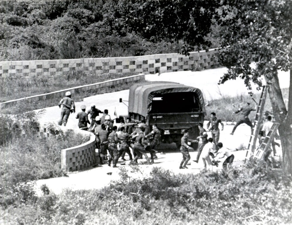 Soldados norte-coreanos atacam uma equipe de poda de árvores em 18 Ago 1976 na Área de Segurança Conjunta, dentro da zona desmilitarizada, que separa a Coreia do Norte e a Coreia Sul, em Panmunjom. Nesse incidente, dois oficiais do Exército dos EUA que serviam na guarda do Comando das Nações Unidas, Maj Arthur G. Bonifas e 1o Ten Mark T. Barrett, foram espancados até a morte por mais de 30 seguranças norte-coreanos. (Foto de Hum Images/Alamy Stock Photo)