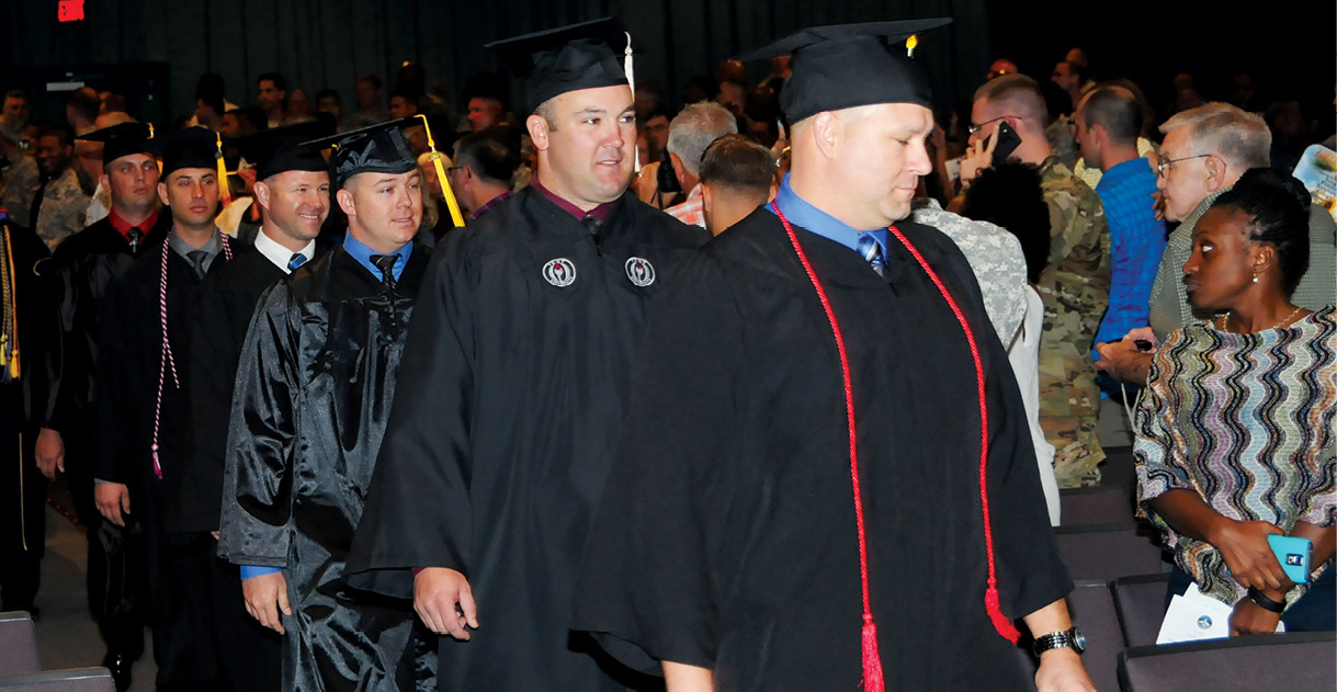 Mais de quarenta formandos sobem ao palco para receber diplomas, desde o nível de graduação ao doutorado, durante cerimônia de formatura do Army Education Center de Fort Rucker, realizada em 13 Mai 16, Fort Rucker, Alabama. (Foto de Nathan Pfau, Army Flier)