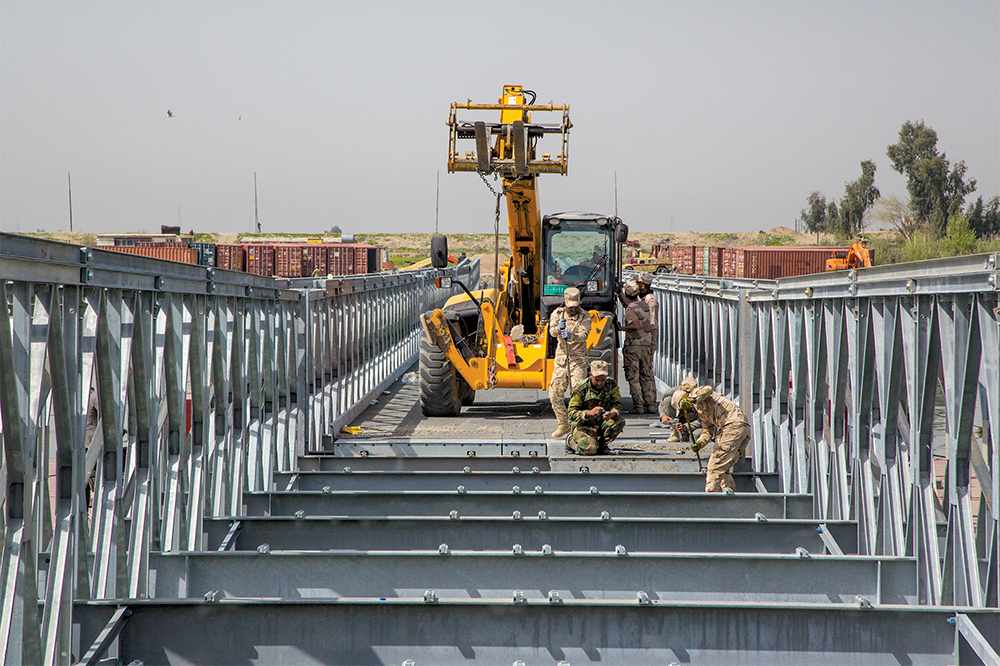 A Equipe de Treinamento de Construção de Pontes do Reino Unido orienta e dá assistência às Forças de Segurança Iraquianas empenhadas na construção da ponte Acrow Poseidon sobre o Rio Tigre, na cidade de Mossul, Iraque, 20 Mar 18. Esse esforço fez parte da Força-Tarefa Conjunta Combinada—Operação Inherent Resolve, a coalizão internacional criada para derrotar o Estado Islâmico no Iraque e na Síria. (Cb Anthony Zendejas IV, Exército dos EUA)