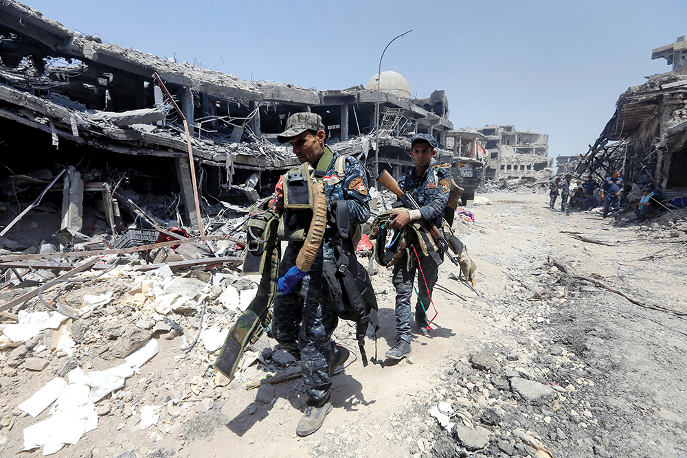 Integrantes da Polícia Federal Iraquiana carregam coletes explosivos capturados de militantes do Estado Islâmico na Cidade Velha de Mossul, Iraque, 09 Jul 17. (Alaa Al-Marjani, Reuters)