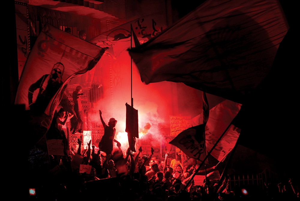 Membros do principal grupo de oposição egípcio, o Movimento Jovem 06 de Abril, acendem iluminativos e gritam frases de propaganda contra a Irmandade Muçulmana durante um protesto em frente ao gabinete do procurador geral em Cairo, 06 Abr 13. Em meio à deterioração da economia, milhares de ativistas saíram às ruas para comemorar o quinto aniversário da fundação do grupo e pressionar o então Presidente Mohamed Morsi com uma longa lista de exigências, incluindo a formação de um governo mais inclusivo. (Foto por Amr Nabil, Associated Press)