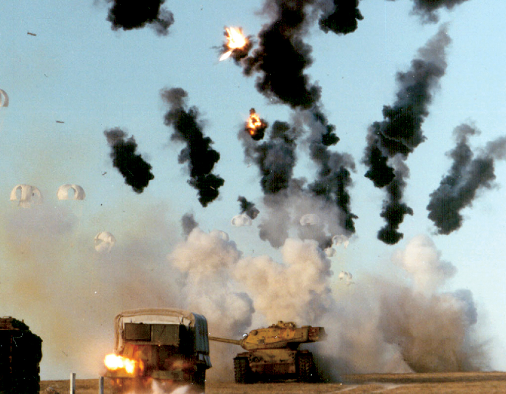 Munições cluster explodem acima de um objetivo em local desconhecido, 14 Set 09. Munições semelhantes foram utilizadas em combate em 02 Abr 03, durante a invasão do Iraque, demonstrando sua capacidade contra uma coluna de carros de combate. (Foto cedida pela Força Aérea dos EUA)