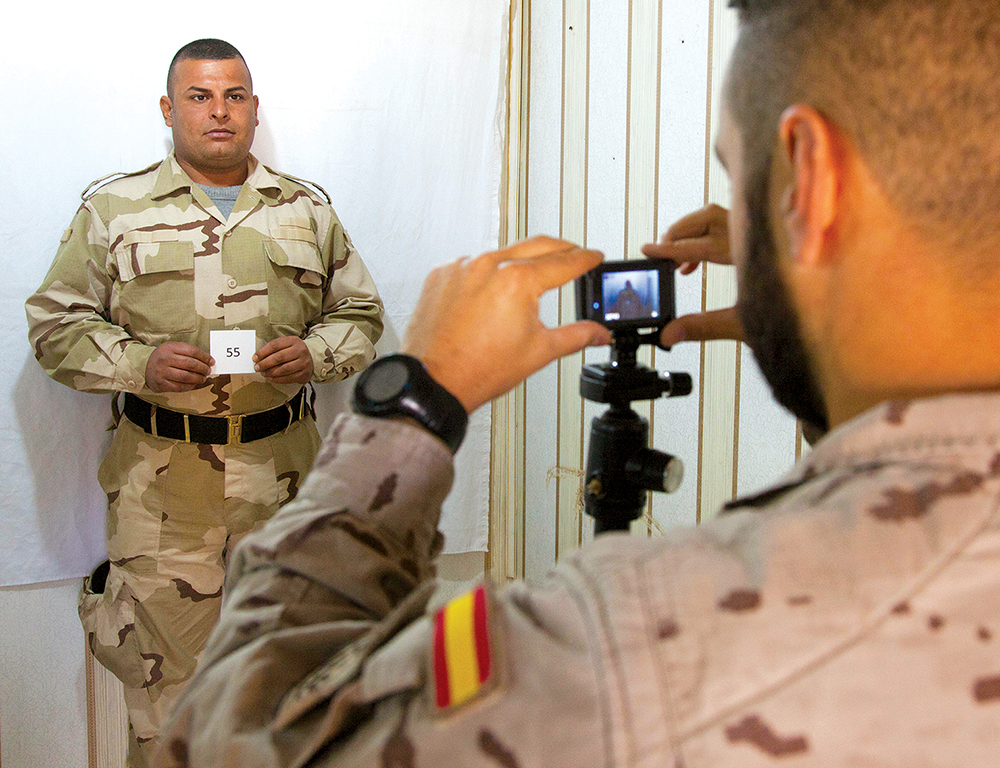 Um instrutor espanhol fotografa um militar das Forças de Segurança Iraquianas (ISF, na sigla em inglês) antes de dar início ao seu curso de treinamento no Campo de Provas Besmaya, 10 Jan 17. Por todo o país, o processo de triagem faz parte da fase inicial para todos os candidatos das ISF. (Sgt Joshua Wooten, Exército dos EUA)