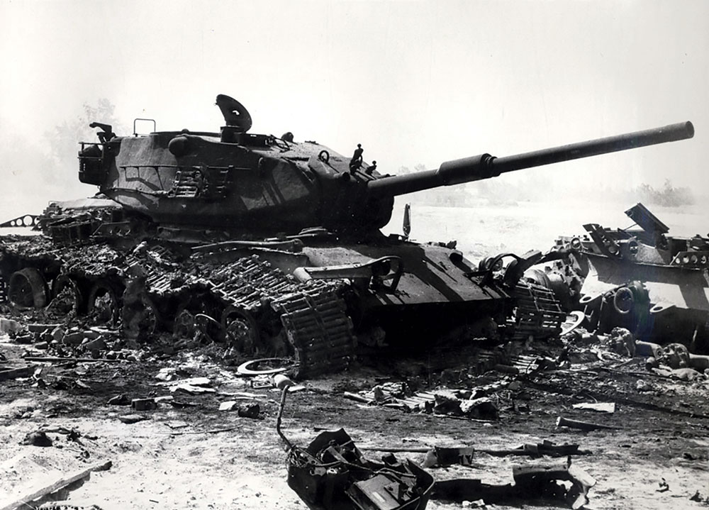 Restos de um carro de combate M60 israelense (fabricado nos EUA) entre os destroços de outros blindados após um contra-ataque israelense no Sinai, perto do Canal de Suez durante a Guerra do Yom Kippur, em 1973. Na transposição inicial do Suez pelas forças egípcias, os líderes israelenses presumiram que os soldados egípcios fugiriam assim que vissem os blindados israelenses, como havia ocorrido na guerra de 1967. No entanto, as forças egípcias haviam estudado as táticas israelenses empregadas na Guerra dos Seis Dias e estavam bem preparadas para se defenderem contra o previsto uso inicial de blindados israelenses. Isso quase resultou em uma catástrofe para as forças israelenses nas fases iniciais do conflito, embora Israel tenha conseguido recuperar a iniciativa mais tarde. (Foto cedida por Military Battles on the Egyptian Front de Gammal Hammad via Wikimedia Commons)
