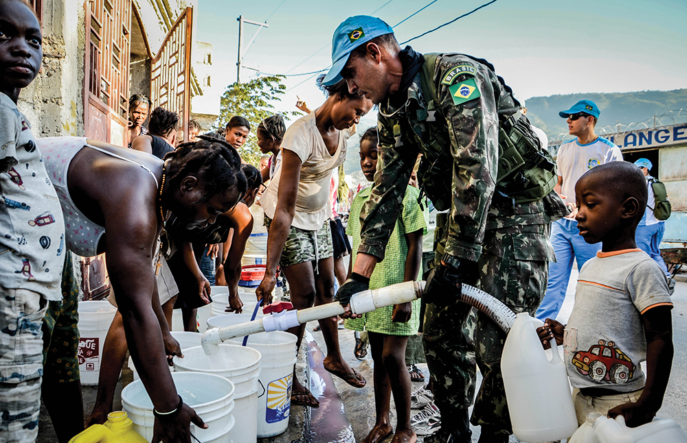 Tropas brasileiras distribuem água à população local como parte das tarefas realizadas em ações cívico-sociais (ACISO). (Foto: Sgt Mache, Exército Brasileiro, CCOMSEX)