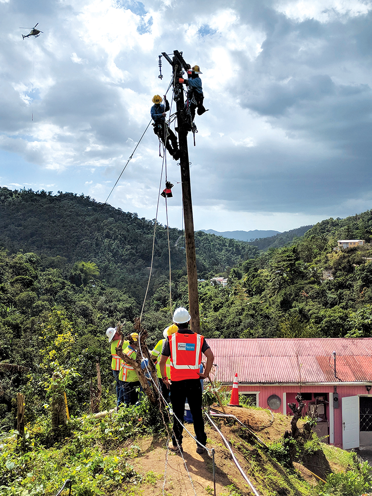 Funcionários do Corpo de Engenheiros do Exército dos EUA colocam postes e linhas de transmissão de eletricidade na comunidade montanhosa de San German, Porto Rico, 06 Fev 18. Durante os primeiros dias, eles cortaram árvores e abriram a densa vegetação com moto-serras para garantir conformidade com os padrões de segurança industriais. Depois, um helicóptero transportou os postes até os lugares designados para sua instalação. (Maj Michael N. Meyer, USACE)