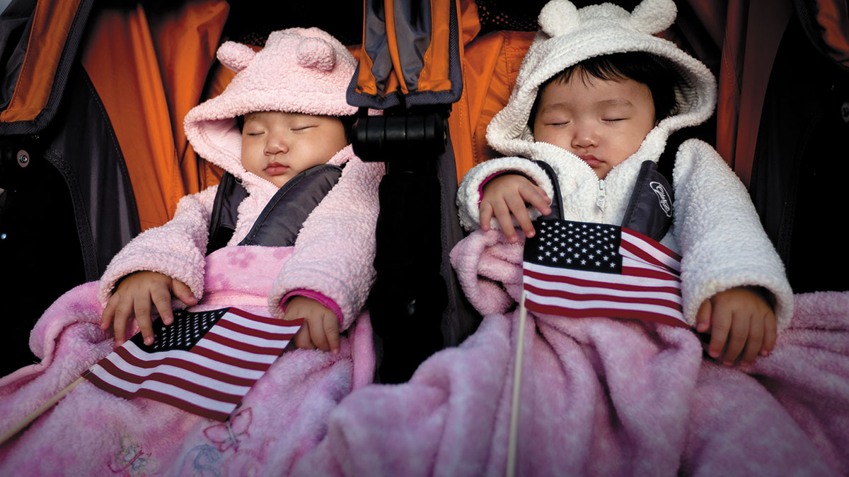 Durante una parte de la celebración de un día de duración del 125º aniversario de la dedicación de la Estatua de Libertad, dos bebés se duermen sosteniendo banderas de EUA en una ceremonia de naturalización para 125 nuevos ciudadanos en la isla Libertad, Nueva York, 28 de octubre de 2011. (Foto: Cuerpo de Infantería de Marina de EUA, Sgto. Randall. A. Clinton)