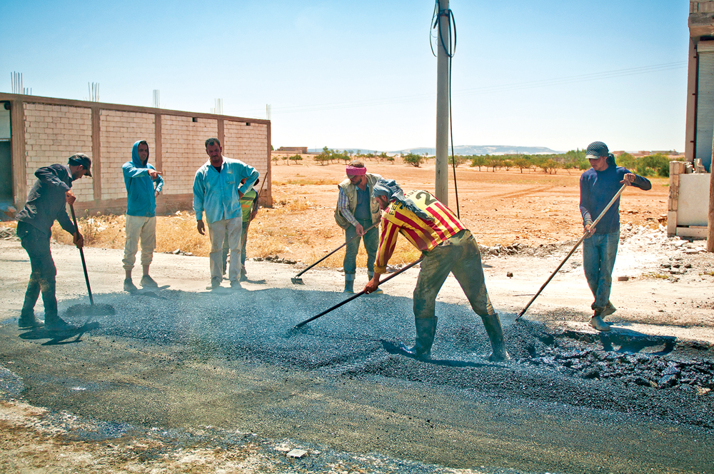 Hombres reparan un camino en una aldea fuera de Manbij, Siria, 11 de julio de 2018. Los esfuerzos de reconstrucción y mantenimiento son señal de que la seguridad y la estabilidad han vuelto a la región desde que las Fuerzas Democráticas Sirias la liberaron del Estado Islámico. (Foto: Sgto. 2<sup>o</sup> Timothy R. Koster, Ejército de EUA)