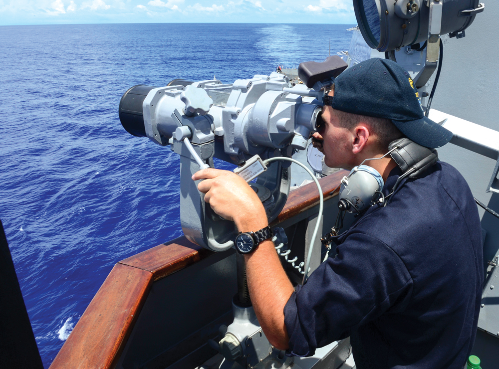 El marinero Alex Case observa un barco de la Armada china desde el puente del USS Sterett, un destructor de la clase Arleigh Burke, el 21 de septiembre de 2014, en un despliegue en el área de operaciones de la 7a Flota en el Pacífico. (Foto: Especialista Eric Coffer, Armada de EUA)