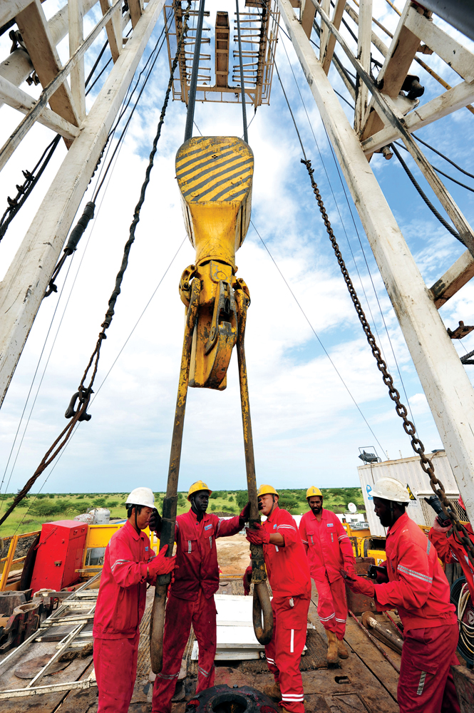 Trabajadores chinos de la Agencia de Exploración Petrolífera Zhongyuan de Sinopec y trabajadores sudaneses perforan un pozo petrolero en el Sur de Sudán, África, el 26 de octubre de 2010. China ha invertido billones de dólares en el sector petrolero y tiene un gran número de trabajadores chinos en los yacimientos petrolíferos de Sudán. El Banco de Importación y Exportación de China recibe un sexto de la producción de petróleo del Sur de Sudán para financiar un gran proyecto de infraestructura en la región central de Sudán. China trabaja con otras naciones africanas para explorar y desarrollar los yacimientos petrolíferos. (Foto: Imaginechina a través de Associated Press)