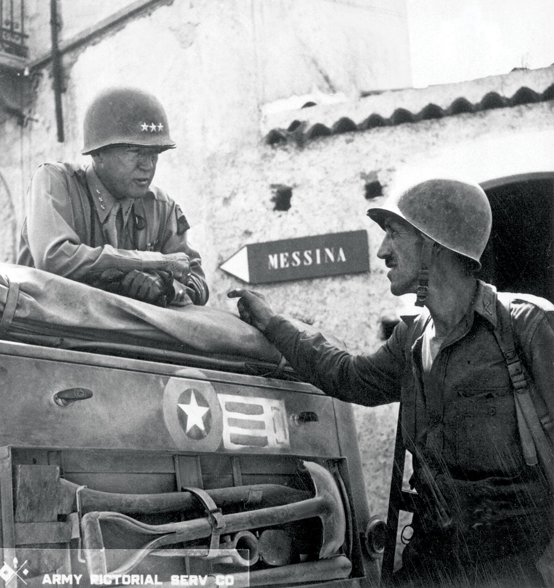 El teniente coronel Lyle Bernard, del 30o Regimiento de Infantería, una figura eminente en el segundo desembarco anfibio tras las líneas enemigas en la costa norte de Sicilia, proporciona una actualización personal al teniente general George S. Patton sobre la situación en el terreno el 10 de julio de 1943, cerca de Brolo, Sicilia. (Foto cortesía de los Archivos Nacionales de EUA)