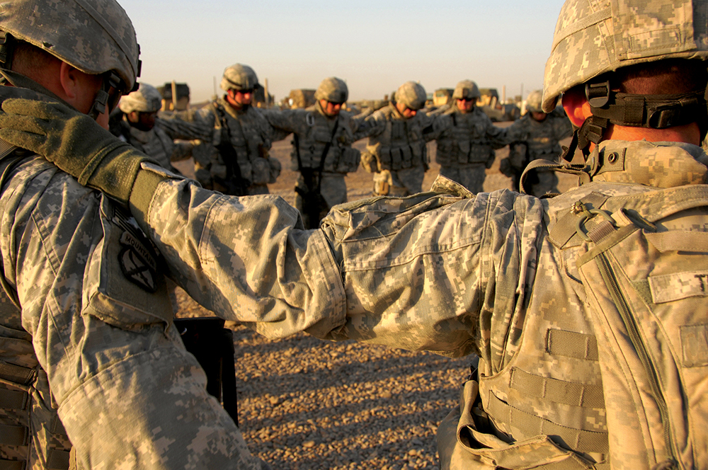 Soldados de la Batería Alfa, 2o Batallón, 32o Regimiento de Artillería de Campaña se juntan para rezar antes de una misión en la Base Operativa Avanzada Liberty, Irak, 29 de octubre de 2007. (Foto: Especialista Charles W. Gill, Ejército de EUA)