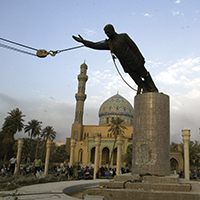 Un soldado del Cuerpo de Infantería de Marina observa mientras derrumban un monumento de Saddam Hussein en la Plaza Firdaus, en el centro de Bagdad, 9 de abril de 2003. (AP Photo/Jerome Delay, Archivo)