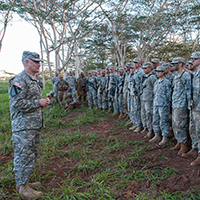 El Sargento Mayor del Ejército Raymond F. Chandler III conversa con soldados asignados al 3er Escuadrón, 4o Regimiento de Caballería, 3er Equipo de Combate de Brigada de la 25a División de Infantería, después de observar una demostración de fuego en vivo en el terreno selvático de Schofield Barracks, estado de Hawái, Ejército de EUA.