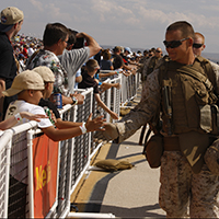 Invitados saludan a los Marines durante el espectáculo aéreo anual patrocinado por los Servicios Comunitarios del Cuerpo de Infantería de Marina de EUA, en la Estación Aérea del Cuerpo de Infantería de Marina en Miramar, estado de California, 2 de octubre de 2010.