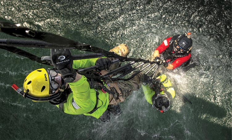 Paracaidistas de rescate de la Fuerza Aérea suben por la escalera de un helicóptero HH-60G Pave Hawk 