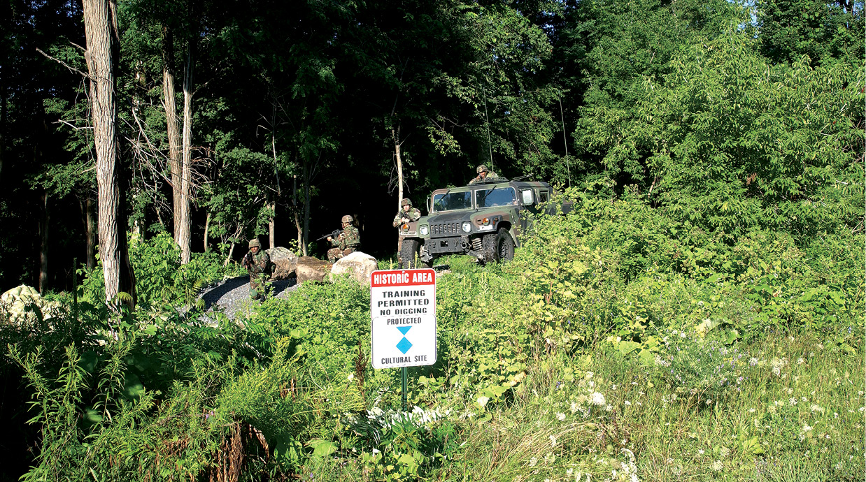 Soldados de la 10a División de Montaña entrenan en las inmediaciones de un sitio cultural protegido el 28 de julio de 2005 en Fort Drum, Nueva York. Parte del entrenamiento de la 10a División de Montaña antes del despliegue es aprender a reconocer y proteger sitios históricos y culturales en peligro. Los sitios protegidos en Fort Drum y sus inmediaciones son un escenario ideal para este tipo de entrenamiento. (Foto de los autores)