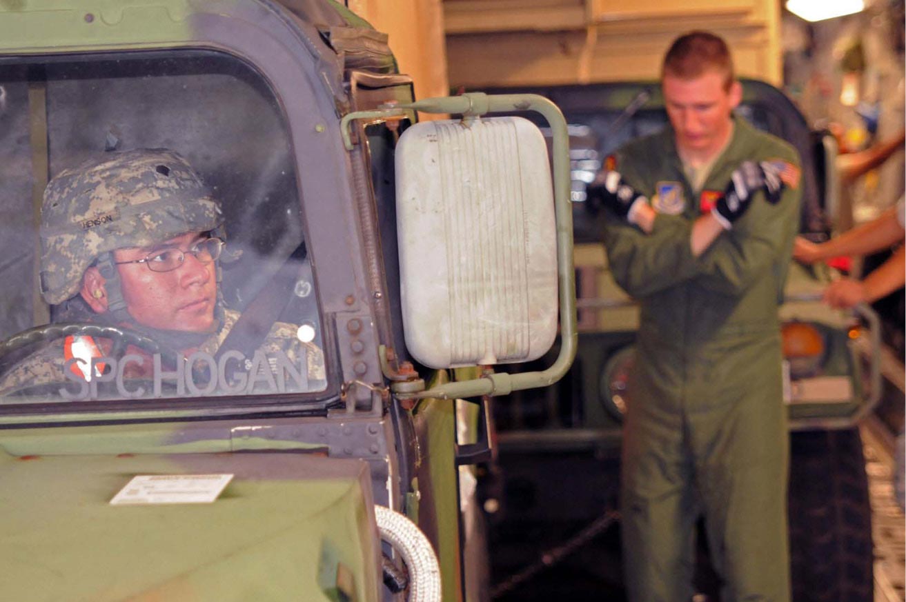 A Soldier with Operations Co., U.S. Army Pacific, watches the hand signals of an Air Force pilot as he loads a High Mobility Multipurpose Wheeled Vehicle into a C-17 on Sept. 21, 2012, at Joint-Base Pearl Harbor Hickam. The plane carried equipment and Soldiers from the U.S. Army Pacific Contingency Command Post (CCP), 311th Signal Command and 25th Infantry Division to Talia Military Camp, Tonga where they will participate in Operation Coral Reef, a week-long combined, joint training exercise.