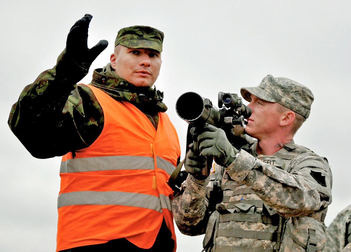 Sgt. Terry Selert of the Pennsylvania National Guard looks to a Lithuanian soldier during a joint live-fire exercise