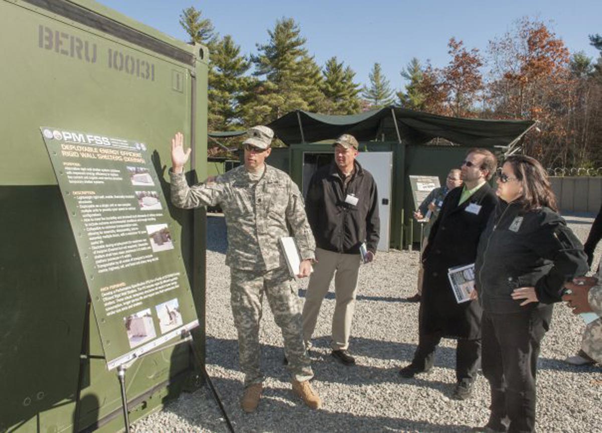 Lt. Col. Ross Poppenberger, Product Manager Force Sustainment Systems, left, speaks with Katherine Hammack, assistant secretary of the Army for Installations, Energy and Environment, about energy-efficient Rigid Wall Camps, on Tuesday during the “Base Camp Resource and Energy Efficiency Day” at the Army Base Camp Integration Laboratory at Fort Devens, Mass.
