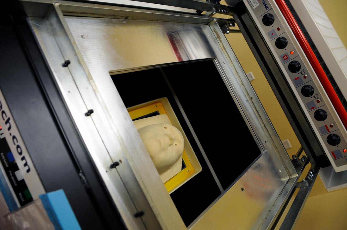 Using a scan of the patients face, technicians use a milling machine to create a mold.