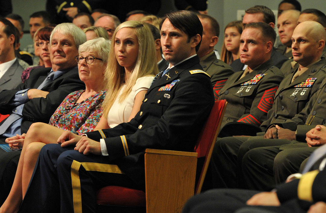 Former Army Capt. William D. Swenson (center) sits with his significant other Kelsey Long, and his parents Julia Buchholz and Carl Swenson, at his induction ceremony into the Pentagon Hall of Heroes, Oct. 16, 2013. Behind Swenson are several of the Marines who served with him at the Battle of Ganjgal, Afghanistan, Sept. 8, 2009. (Photo by J.D. Leipold)