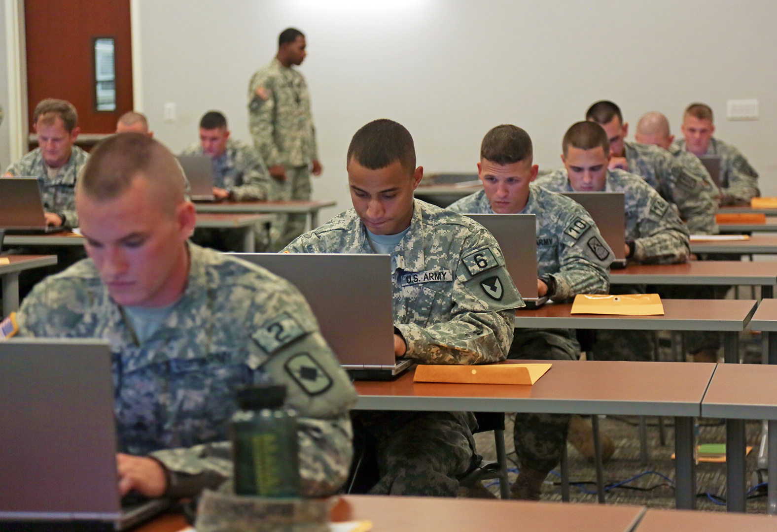 An NCO on the organizing staff observes competitors as they compose their essays during the first day of the 2014 Best Warrior Competition on Monday at Fort Lee. (Photo by Spc. Jordan Talbot)